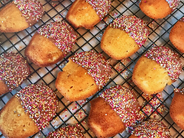 Madeleines dipped in chocolate dusted with 100s and 1000s
