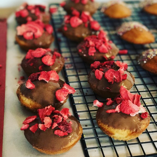 Madeleine cupcakes dipped in chocolate, sprinkled with freeze dried strawberries
